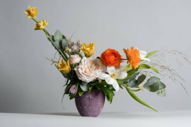 yakın çekim fotoğraf gri arka plan üzerinde mor kavanoza güzel renkli çiçeklerin