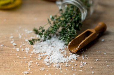 tahta kaşık ahşap masa arka plan üzerinde deniz tuzu ile taze yeşil biberiye yakın çekim fotoğraf