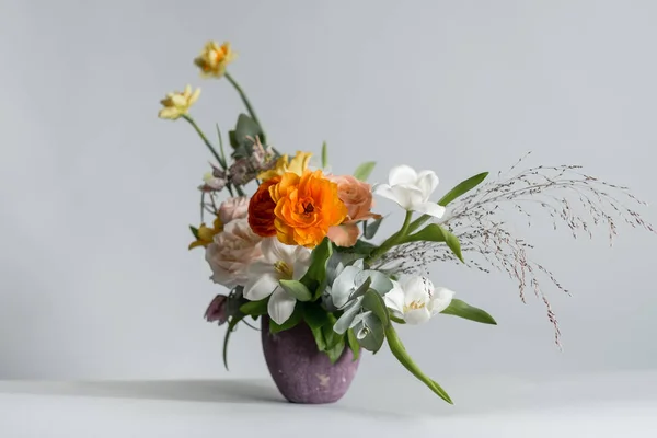 灰色の背景の紫瓶に美しい色の花のクローズ アップ写真 — ストック写真