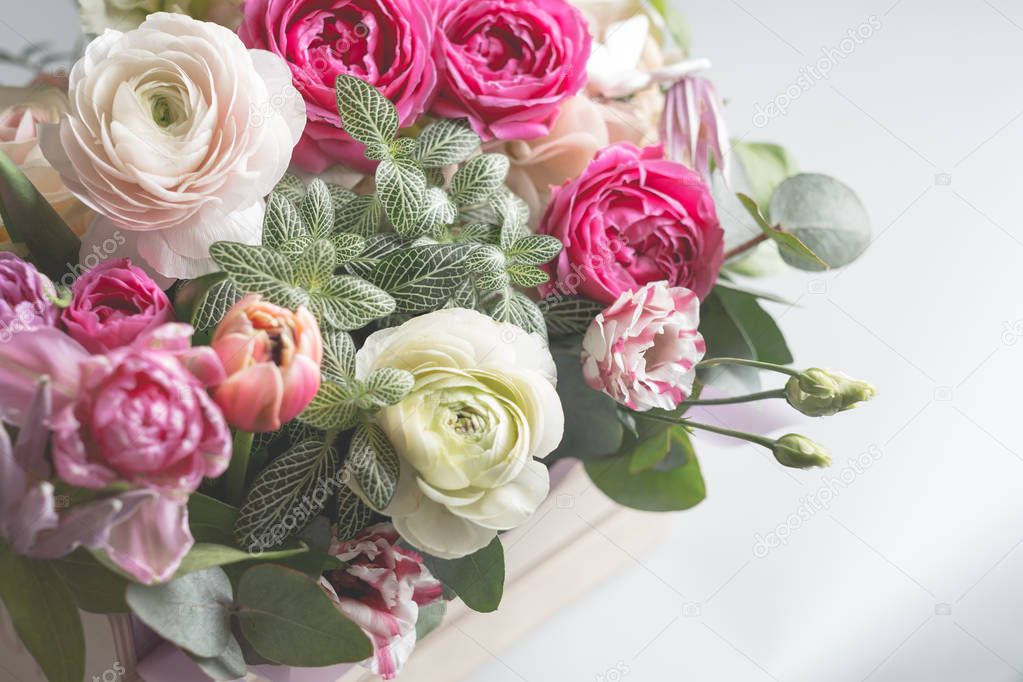 photo of beautiful colored flowers in wooden box on grey background