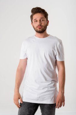 genç yakışıklı sakallı adam gri arka plan üzerinde Beyaz gömlekli portresi 