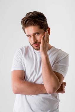 gri arka plan üzerinde Beyaz tişörtlü genç seksi sakallı adam portresi 