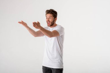 Sakallı genç portresi adam gri arka plan üzerinde beyaz gömlek jest olarak tiksinti 