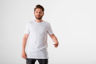 gri arka plan üzerinde Beyaz tişörtlü genç sakallı adam portresi 