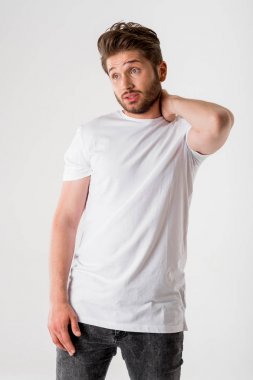 gri arka plan üzerinde Beyaz tişörtlü genç düşünceli sakallı adam portresi 