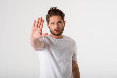 Genç sakallı adam jest dur işareti gri arka plan üzerinde Beyaz gömlekli portresi 