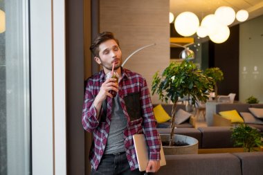 holding ve arka plan üzerinde taze suyu kapalı içme ekose gömlekli genç sakallı adam portresi