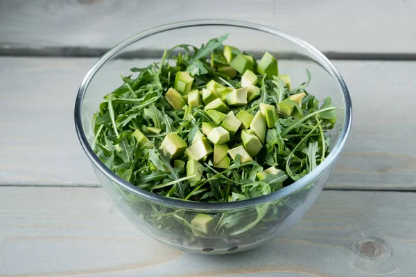 新鮮なグリーン サラダ アボカド ルッコラ ホウレンソウのテーブルの上のガラスのボウルのクローズ アップ写真 — ストック写真