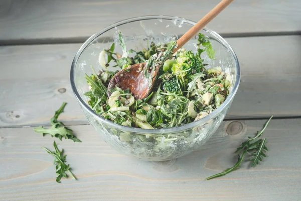 おいしいサラダ ルッコラとほうれん草のテーブルで木のスプーンとガラスのボウルのクローズ アップ写真 — ストック写真