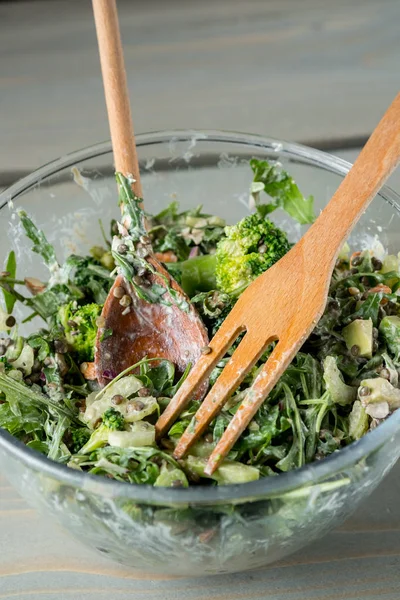 新鮮なグリーン サラダ ルッコラとほうれん草の木製フォークとスプーンをテーブルの上にボウルのクローズ アップ写真  — 無料ストックフォト