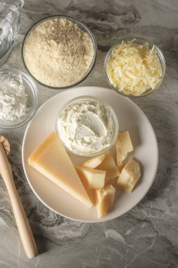 Tabak manzaralı peynirli peynirli peynirli cheesecake pişirme malzemeleri masa arkasında yatıyordu. Ev yapımı yemek konsepti.