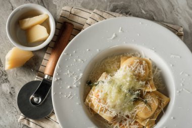 Peynirli parmesan peynirli makarna ve baharatlı İtalyan yemeği tarifi mutfak arka planında..