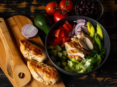 Taze diyet sağlıklı salata ızgara tavuk ve organik sebzeler siyah arka planda, fotokopi alanı metin menüsü ve tarifi için düz görüş