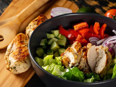 Taze diyet sağlıklı salata ızgara tavuk ve organik sebzeler siyah arka planda, fotokopi alanı metin menüsü ve tarifi için düz görüş