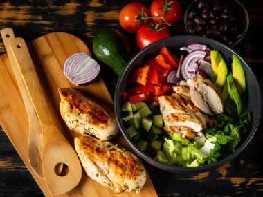 Taze diyet sağlıklı salata ızgara tavuk ve organik sebzeler siyah arka planda, fotokopi alanı metin menüsü ve tarifi için düz görüş