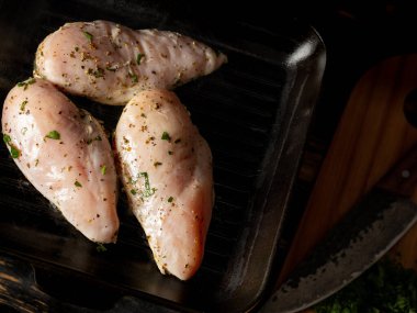 Tavuk fileto ızgarada pişiyor Şefin elleriyle siyah arka planda