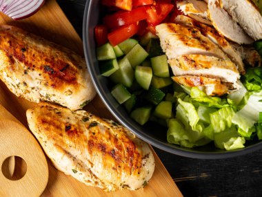 Taze diyet sağlıklı salata ızgara tavuk ve organik sebzeler siyah arka planda, fotokopi alanı metin menüsü ve tarifi için düz görüş