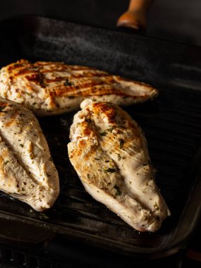 Tavuk fileto ızgarada pişiyor Şefin elleriyle siyah arka planda