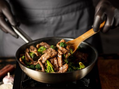 Brokoli sebzeli biftek çelik tavada kızartılıyor..