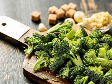 Tahta masada kesilmiş taze sağlıklı brokoli sebzeleri. Kapatın. Vejetaryen yemek tarifi konsepti.