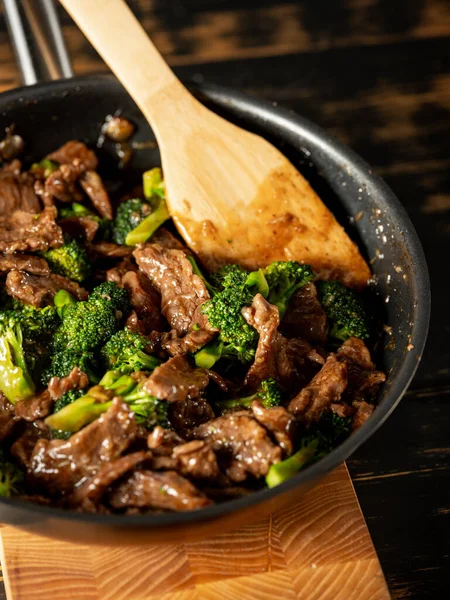 Beef with broccoli vegetables cooking roasting in steel pan.