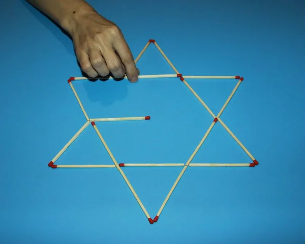 hand fingers take rearrange connects Wooden matches solves puzzl
