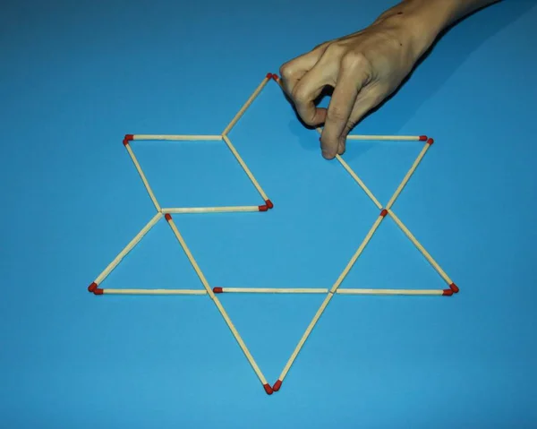 hand fingers take rearrange connects Wooden matches solves puzzl