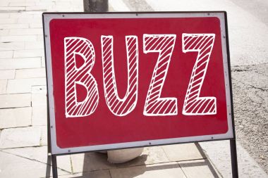 Kavramsal el Buzz gösterilen metin resim yazısı ilham yazma. İş kavramı için duyuru yol işaret arka plan ve kopya alanı ile yazılı Buzz kelime llustration