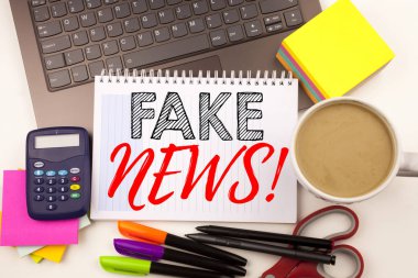 Dizüstü bilgisayar, marker, kalem, ileti örneği, kahve ile ofiste sahte haber yazma kelime. İş kavramı kopya alanı ile Propaganda gazete sahte haber atölye beyaz arka planı için