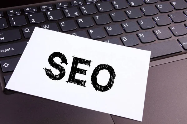 SEO Search Engine Optimization skriver tekst laget på kontoret ved hjelp av laptop-tastatur. Forretningskonsept for SEO på svart bakgrunn med kopiplass – stockfoto