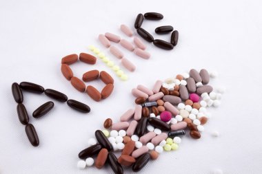 Uyuşturucu kelime yaşlanma yaş beyaz izole arka planda kopya alanı ile kapsül hap ile yazılı metin resim yazısı ilham tıbbi bakım kavramı yazma el