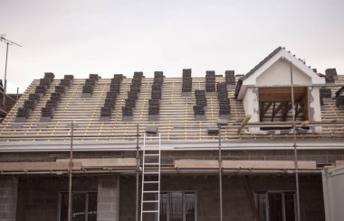Çatı Kaplama ve ayakları veya yeni bir, iki hikaye, ticari apartmanın merdiven üzerinde çalışıyor