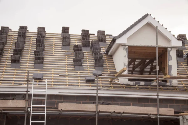 Working on the roof sheeting and outriggers or ladder of a new, two story, commercial apartment building — Stock Photo, Image