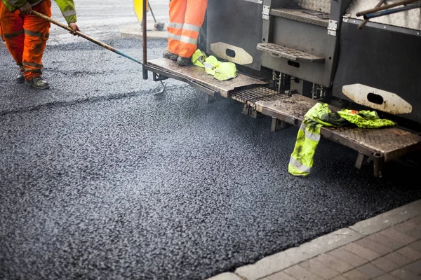 A roadworks on the street new asphalt with worker — Stock Photo, Image