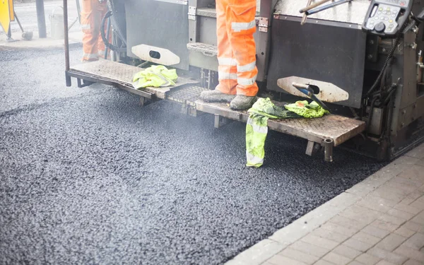 Uma estrada trabalha na rua novo asfalto com o funcionário — Fotografia de Stock