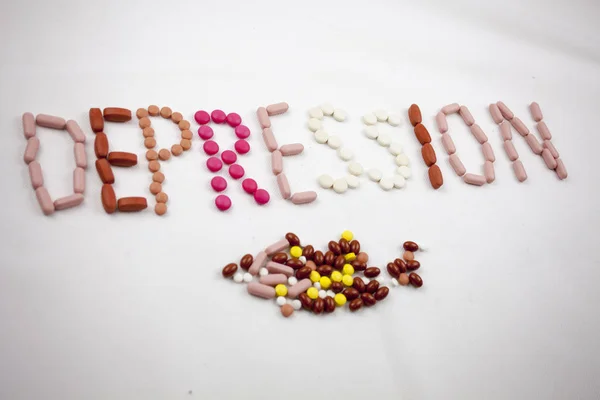 Een woord van depressie, schrijven op de witte achtergrond op pillen — Stockfoto