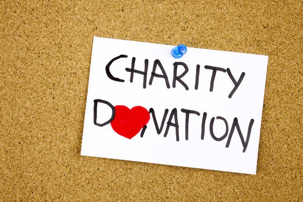 Frase de donación de caridad escrita a mano en una nota pegajosa fijada a un símbolo de corazón de aviso de corcho en lugar de O —  Fotos de Stock