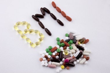 Kavramsal el ile hap ilaç kapsül word kısaltma BMI - vücut kitle endeksi izole beyaz arka plan kopya alanı ile yazılı metin resim yazısı ilham tıbbi bakım sağlık kavramı yazma