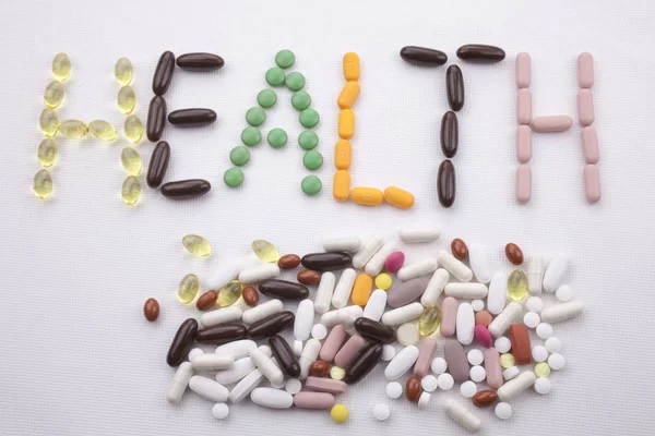 Kavramsal el ile hap ilaç kapsül word sağlık sezon beyaz izole arka plan kopya alanı ile yazılı metin resim yazısı ilham tıbbi bakım sağlık kavramı yazma
