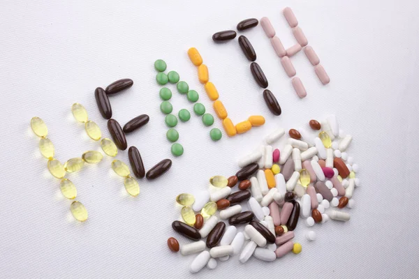 Kavramsal el ile hap ilaç kapsül word sağlık sezon beyaz izole arka plan kopya alanı ile yazılı metin resim yazısı ilham tıbbi bakım sağlık kavramı yazma