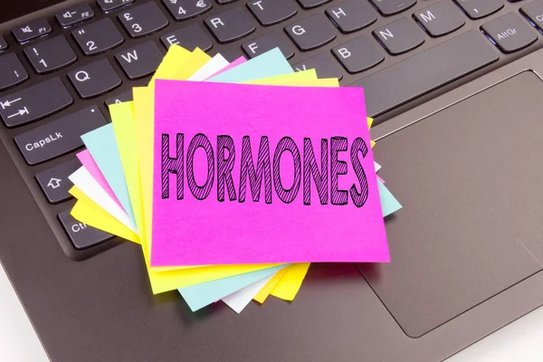 Escribir Hormonas texto hecho en el primer plano de la oficina en el teclado del ordenador portátil. Concepto de negocio para el taller de la píldora hormonal en el fondo negro con espacio de copia —  Fotos de Stock