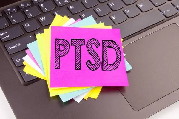 Escrevendo PTSD Post-Traumatic Stress Disorder texto feito no close-up escritório no teclado do computador portátil. Conceito de negócio para Oficina de Tratamento de Saúde no fundo preto com espaço de cópia — Fotografia de Stock