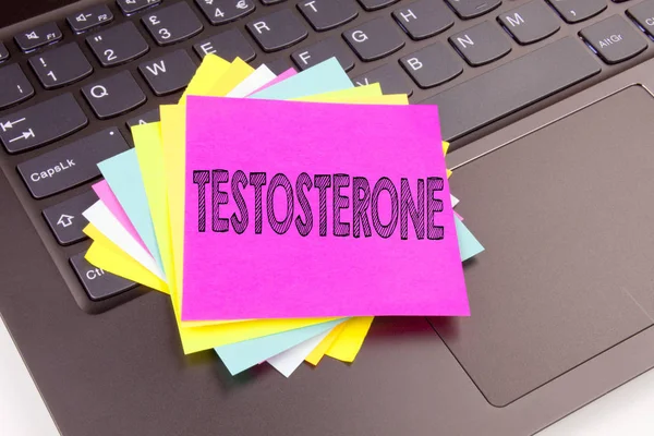 Escrevendo texto de testosterona feita no close-up escritório no teclado do computador portátil. Conceito de negócio para a oficina esteroide masculina da molécula da hormona no fundo preto com espaço de cópia — Fotografia de Stock