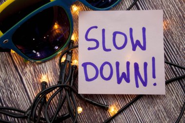 Vintage yapışkan not ahşap arka plan üzerinde yavaş ol - yaşam tarzı kavramı - izole metin. Handwitting