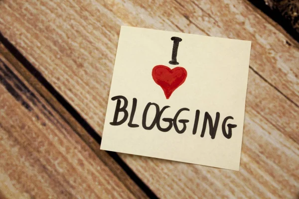 Adoro bloggare scritto a mano con nota rigida bianca su uno sfondo di legno — Foto Stock