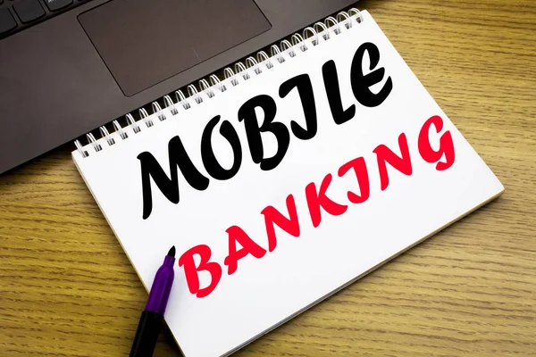 Hand writing text caption inspiration showing Mobile Banking. Business concept for Internet Banking e-bank written on notebook book on the wooden background in the Office with laptop