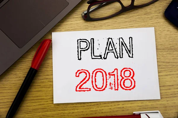 Handskrift tillkännagivande text visar Plan 2018. Affärsidé för planering strategi handlingsplanen skrivet på papper, trä bakgrund i kontor med kopia utrymme, tuschpenna och glasögon — Stockfoto