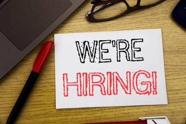 Biz çoğu işe şimdi gösteren el yazısı duyuru metin. İş kavramı için işe alım insan kaynakları içinde yazıhane kopya alanı, pen marker ve gözlük ile kağıt, ahşap arka plan üzerinde yazılı