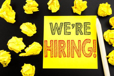 Biz çoğu işe şimdi gösteren el yazısı metin. İş kavramı için işe alım insan kaynakları yapışkan not kağıdına siyah arka plan üzerinde yazılı yazma. Sarı kağıtları arka plan üzerinde katlanmış