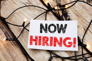 El yazısı metnini başlık Şimdi Kiralama gösterilen. İş kavramı kiralık ahşap arka plan üzerinde yapışkan not kağıt üzerinde yazılı işe alım için yazma.